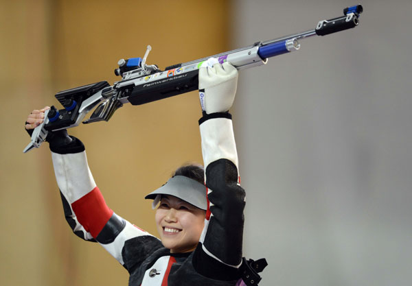 China's Yi Siling gestures as she celebrates her gold medal after the 10m air rifle women's final of the London Olympic Games at the Royal Artillery Barracks in London on Saturday. Cui Meng / China Daily Yi shot for the gold and hit the mental mark