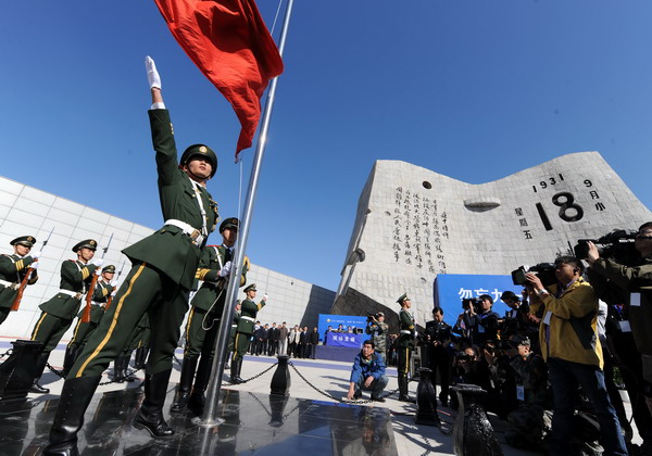 A flag-raising ceremony is held in front of the Sept 18 Museum in Shenyang, capital of Liaoning province, on Sunday. Bells toll to mark Japanese invasion