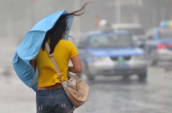 A woman braves the rain as typhoon Nesat approaches in Sanya, Hainan province, Sept 29, 2011. 300,000 evacuated as typhoon Nesat lands