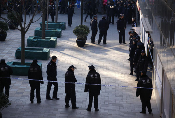 Police stand guard outside an Apple store after they dispersed a crowd from the front of the building in the Beijing district of Sanlitun January 13, 2012. A crowd of a few hundred people gathered outside the store from early morning on the first day of sales in China for Apple's iPhone 4S, but police were called to disperse the crowd after a disgruntled customer threw eggs at the store. Apple suspends iPhone 4S sales in Beijing, Shanghai