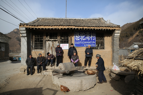 Villagers grind soybeans at a yard in Luotuowan village, Fuping County, Dec 31, 2013. Poor village gets $48 million after Xi's visit