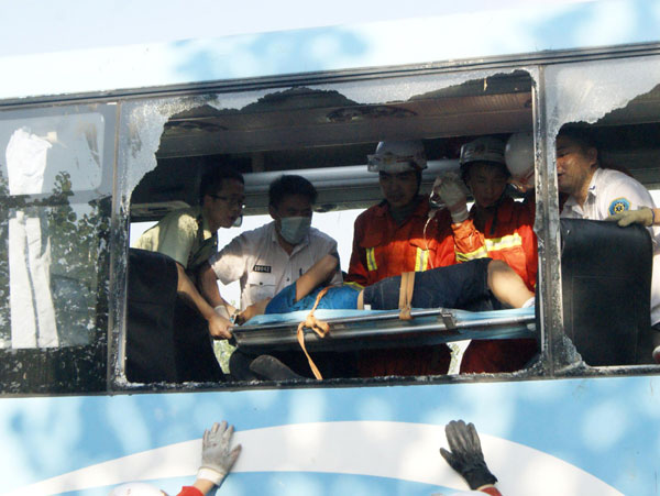 Rescuers carry a victim out of the coach crashed in a road accident in Hefei city, the capital of East China's Anhui province, Aug 9, 2013. 10 killed in E China expressway collision