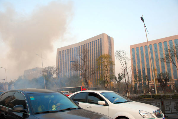 Smoke rises near the office building of the Shanxi provincial Party committee in Taiyuan on Wednesday. Police are investigating the bomb blasts that killed one and injured eight. Liu Guoliang / Xinhua Police look for black Santana in blast probe