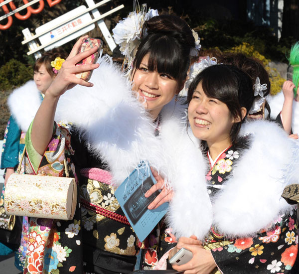 Girls wearing kimonos pose for a picture during their Coming of Age Day event, Jan 9, 2012. 'Coming of Age Day' with record low number of new adults
