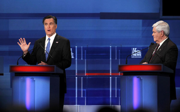 Republican presidential candidate former Massachusetts Governor Mitt Romney speaks as former House Speaker Newt Gingrich listens during in a Republican presidential candidates debate in Myrtle Beach, South Carolina, Jan 16, 2012. Republicans look to slow Romney momentum at debate