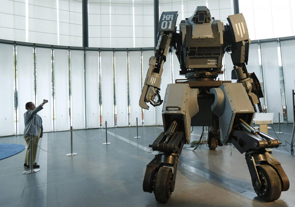 A man takes a picture of a giant 'Kuratas' robot at an exhibition in Tokyo November 28, 2012. <EM>Real Steel</EM> in real world