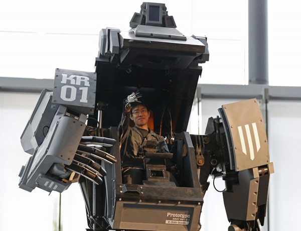 Robotics expert Watanaru Yoshizaki demonstrates how to operate the arm of a giant 'Kuratas' robot at an exhibition in Tokyo November 28, 2012. The four-meter-high, limited edition, made-to-order robot is controlled through a pilot in its cockpit, or via a smartphone. <EM>Real Steel</EM> in real world
