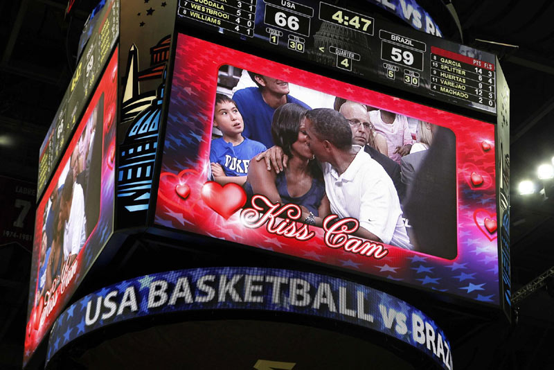 US President Barack Obama and first lady Michelle Obama are shown kissing on the 'Kiss Cam' screen during a timeout in the Olympic basketball exhibition game between the US and Brazil national men's teams in Washington, on July 16, 2012. 2012 Sports Photos in Review: Off the court