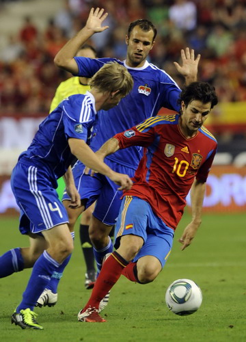 Spain's Cesc Fabregas (R) is challenged by Liechtenstein's Martin Rechsteiner (L) and Marc Ritzberger (top) during their Euro 2012 Group I qualifying soccer match at the Las Gaunas stadium in Logrono, northern Spain, Sept 6, 2011. Spain qualify for Euro 2012 with easy win