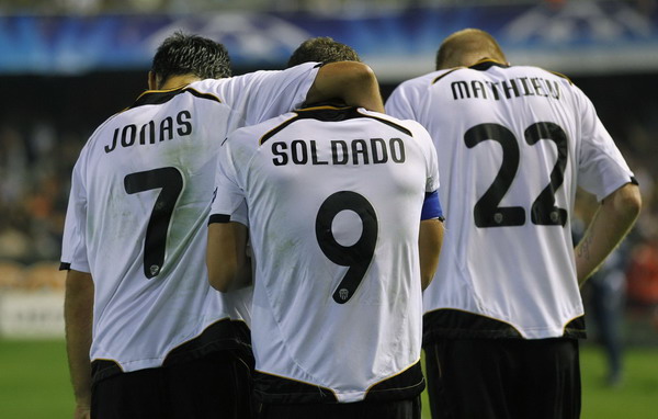 Valencia's Roberto Soldado (C) is congratulated by teammates Jonas (L) and Jeremy Mathieu after scoring a goal against Bayer Leverkusen during their Champions League Group E soccer match at Mestalla stadium in Valencia Nov 1, 2011. Lightning-quick goal leads Valencia to first win