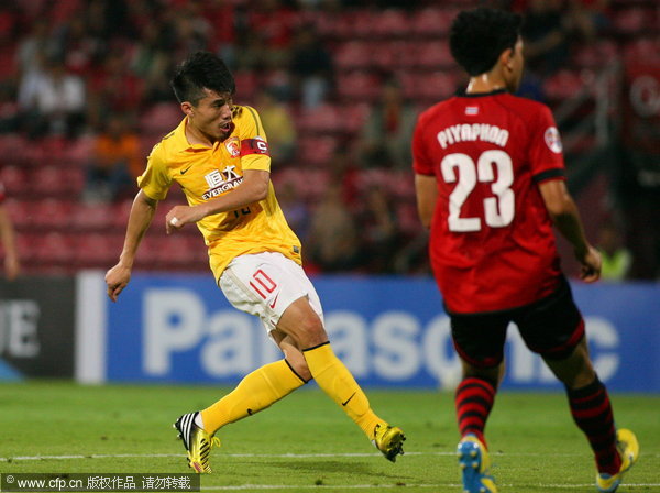 Skipper Zheng Zhi, left, of Guangzhou Evergrande shoots against Muangthong United during their AFC Champions League game in Mongkok, Thailand, April 9, 2013. Guangzhou Evergrande close to ACL final 16