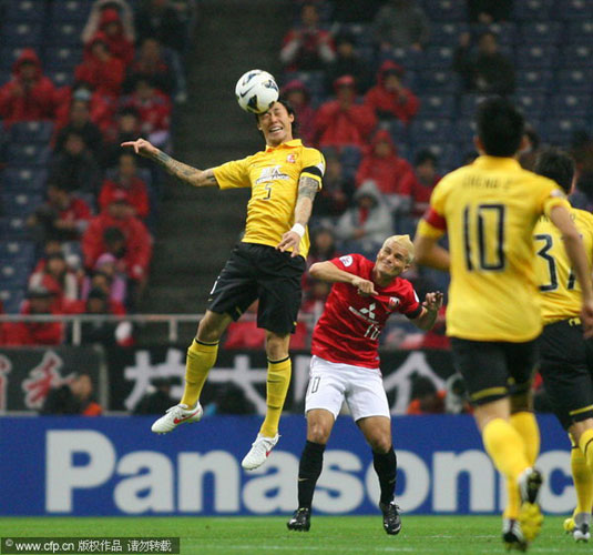Zhang Linpeng, left, of Guangzhou Evergrande jumps for a ball during their Asian Champions League Group F game against Japan's Urawa Reds in Saitama, Japan, April 24, 2013. Guangzhou Evergrande advances into knockout stage despite loss, expulsion