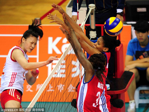 Hui Ruoqi, left, of China spikes against Cuban players during their Shenzhen International Volleyball Tournament in Guangzhou, Guangdong province, May 24, 2013. China claims second title under Lang's charge