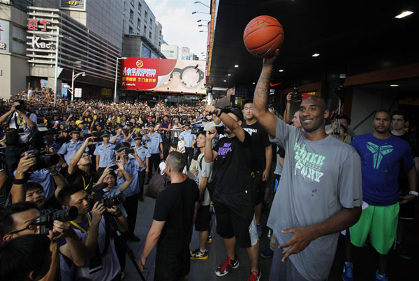 Los Angeles Lakers NBA star Kobe Byrant greets fans as thousands cheer outside a sports store in the southern Chinese city of Shenzhen August 4, 2013. Kobe Byrant meets fans in Shenzhen