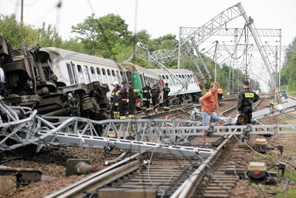 Emergency services personnel inspect the wreckage of a passenger train that derailed near the village of Baby, in central Poland, Aug 12, 2011. Polish train derails, 4 people killed