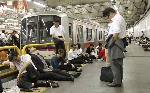 Passengers wait for the resumption of train service after it was halted by Typhoon Roke, at Shibuya station in Tokyo Sept 21, 2011. Typhoon kills 6 in Japan, nuke plant not affected