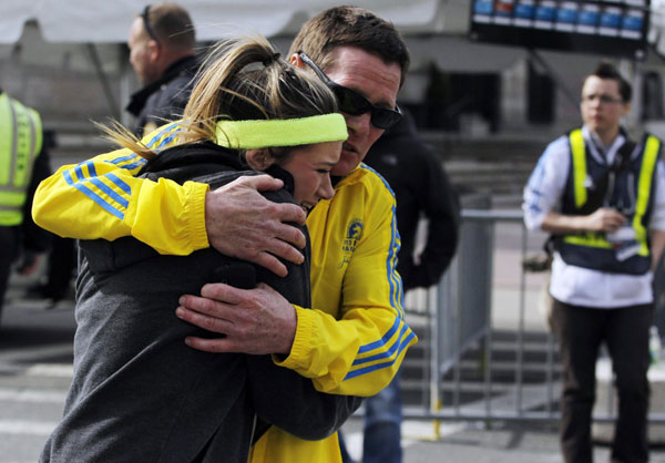 A woman is comforted by a man near a triage tent set up for the Boston Marathon after explosions went off at the 117th Boston Marathon in Boston, Massachusetts, April 15, 2013. Three dead in US marathon bomb