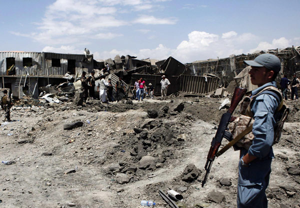An Afghan policeman stands at the site of a suicide attack in Kabul July 2, 2013. Taliban insurgents including a suicide bomber in a truck killed six people in the attack on a foreign logistics and supply company in Kabul on Tuesday NATO supplier's compound attacked in Afghanistan