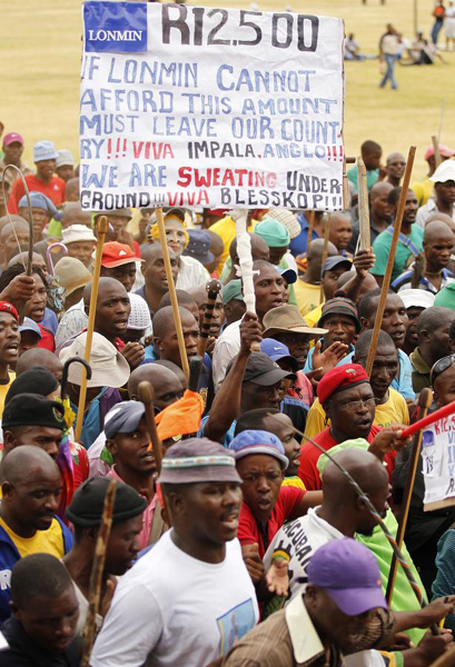 Miners gather at Wonderkop stadium outside the Lonmin mine in Rustenburg, northwest of Johannesburg, in this Jan 30, 2014 file photo. Mine strike hits S. African economy